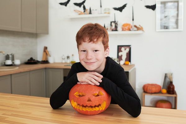 Boy Put His Hands on Top of Halloween Pumpkin